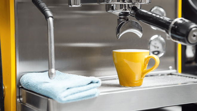 espresso coffee machine with a yellow coffee cup and microfibre cleaning cloth